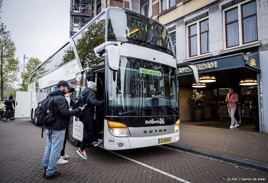 Drie bussen arriveren onder politiebeveiliging bij Schiphol